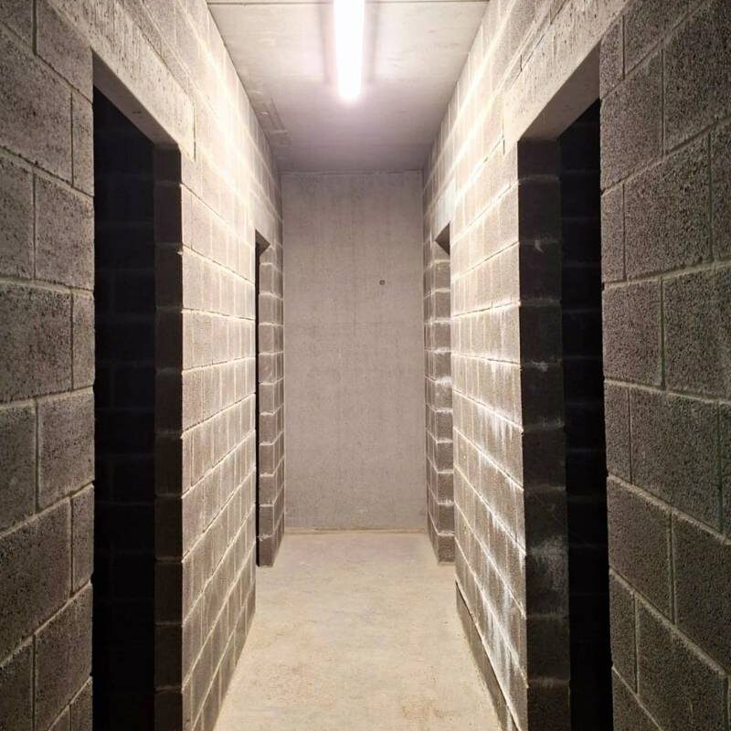 Couloir d'un immeuble à appartements à Wavre avec une lampe installée par BMD Electricité