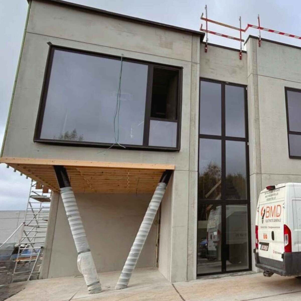 Arrière d'une camionnette de BMD garée devant un bâtiment en construction à Seneffe pendant l'installation de l'électricité